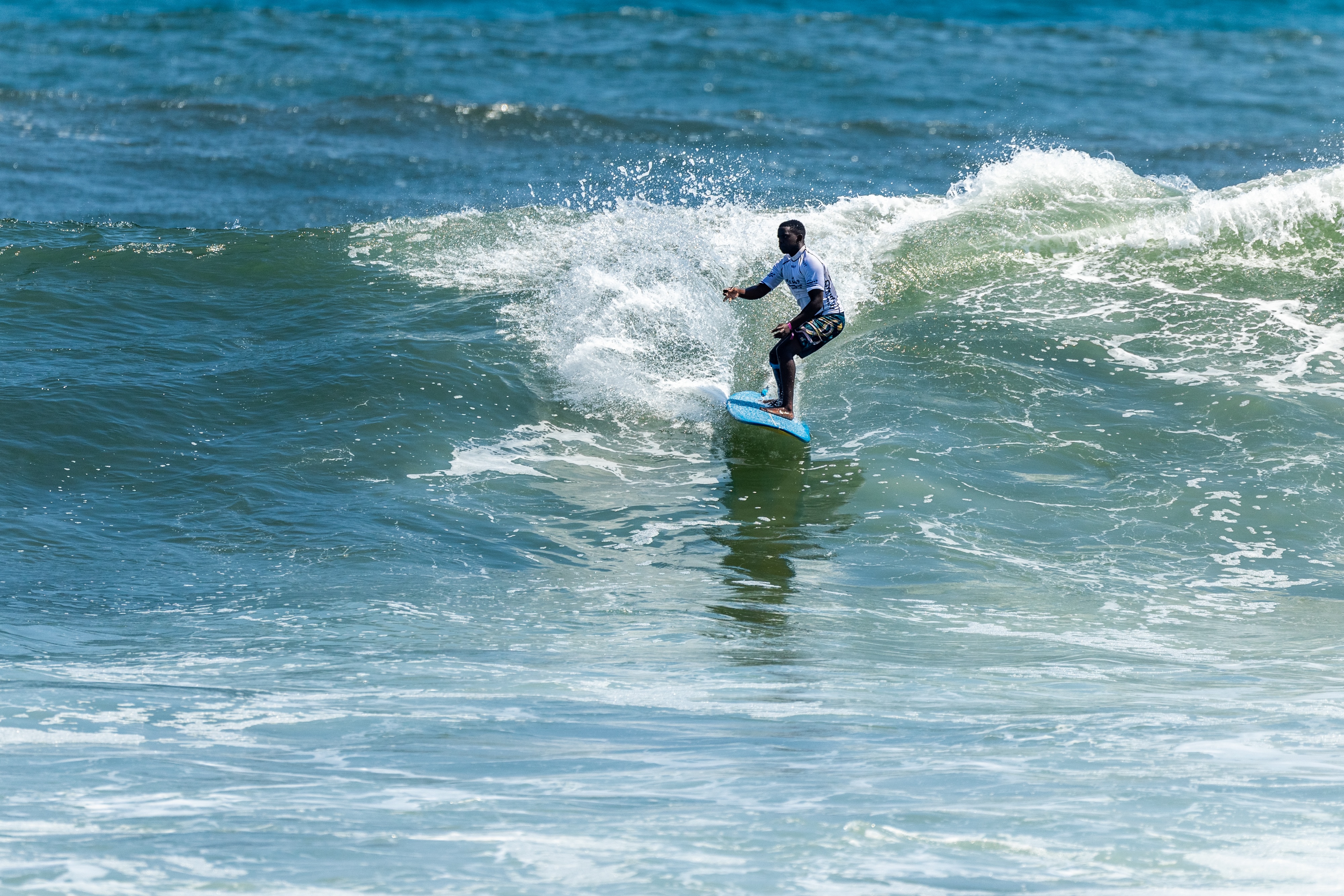 A surfer from Cape Town, South Africa surfing a wave during a competition.
DE: Ein Surfer aus Kapstadt, Südafrika, surft während eines Wettbewerbs auf einer Welle.
NL: Een surfer uit Kaapstad, Zuid-Afrika surft op een golf tijdens een wedstrijd.