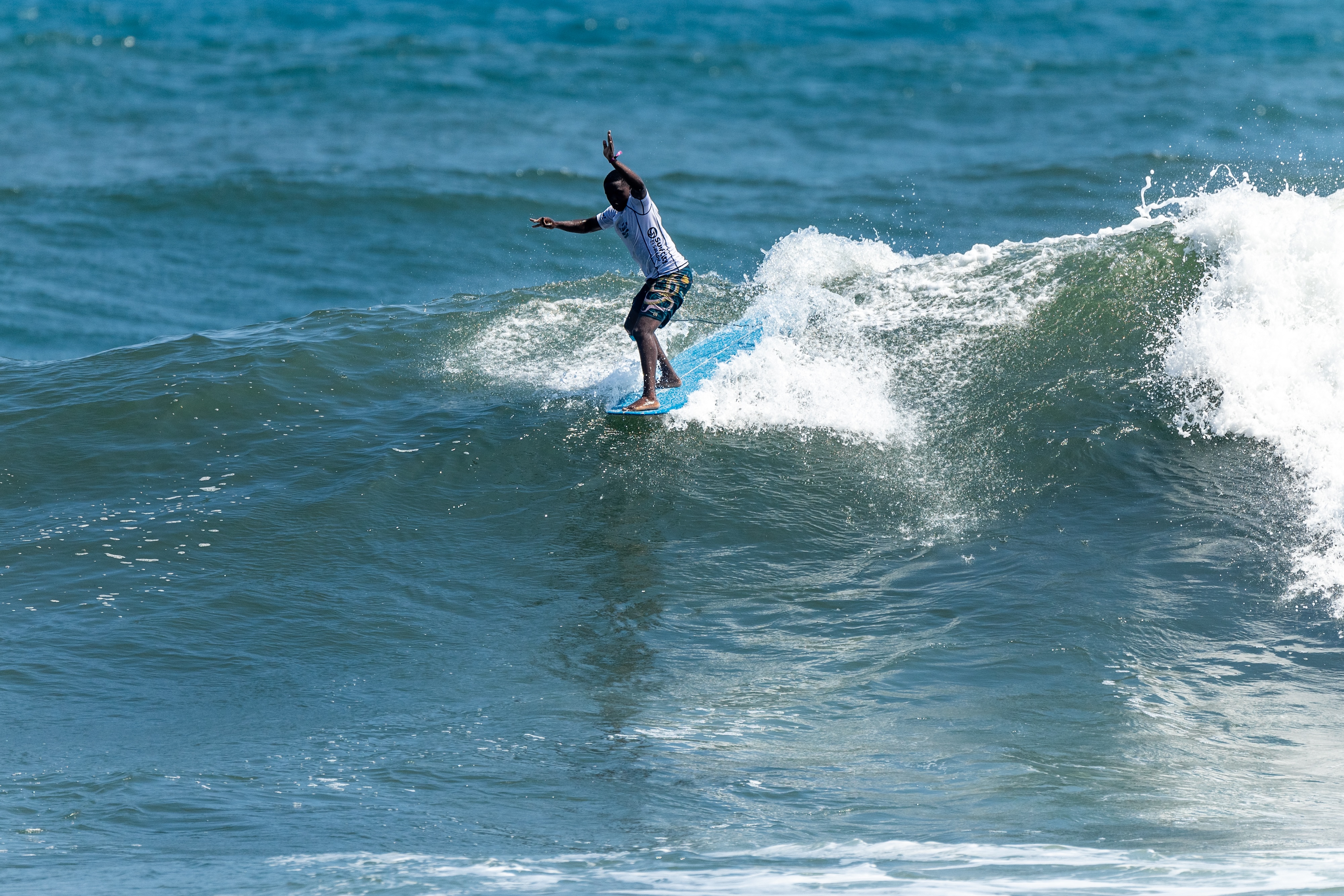 A surfer from Cape Town, South Africa surfing a wave during a competition doing a hang 5.
DE: Ein Surfer aus Kapstadt, Südafrika, surft während eines Wettbewerbs auf einer Welle und macht einen Hang 5.
NL: Een surfer uit Kaapstad, Zuid-Afrika surft op een golf tijdens een wedstrijd en doet een hang 5.