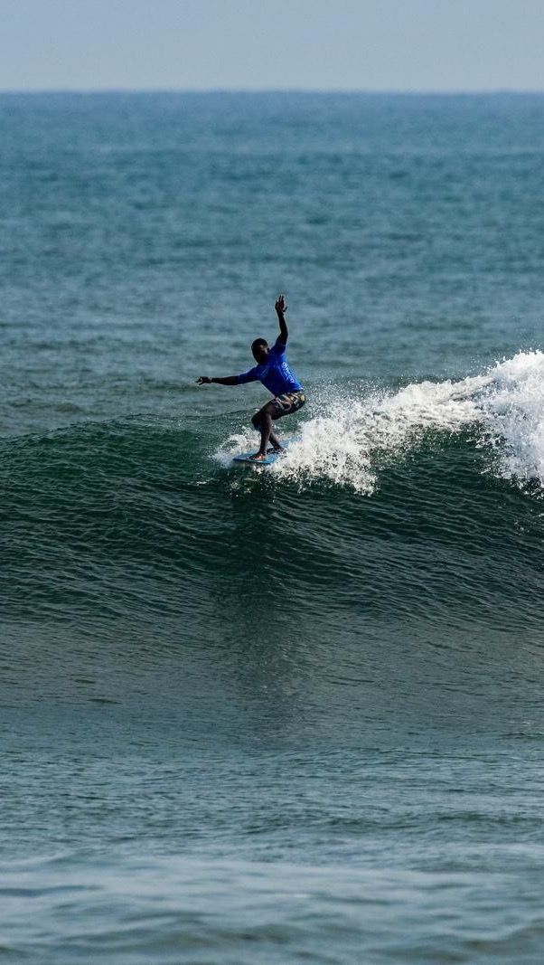 A surfer from Cape Town, South Africa surfing a wave during a competition doing a hang 5.
DE: Ein Surfer aus Kapstadt, Südafrika, surft während eines Wettbewerbs auf einer Welle und macht einen Hang 5.
NL: Een surfer uit Kaapstad, Zuid-Afrika surft op een golf tijdens een wedstrijd en doet een hang 5.